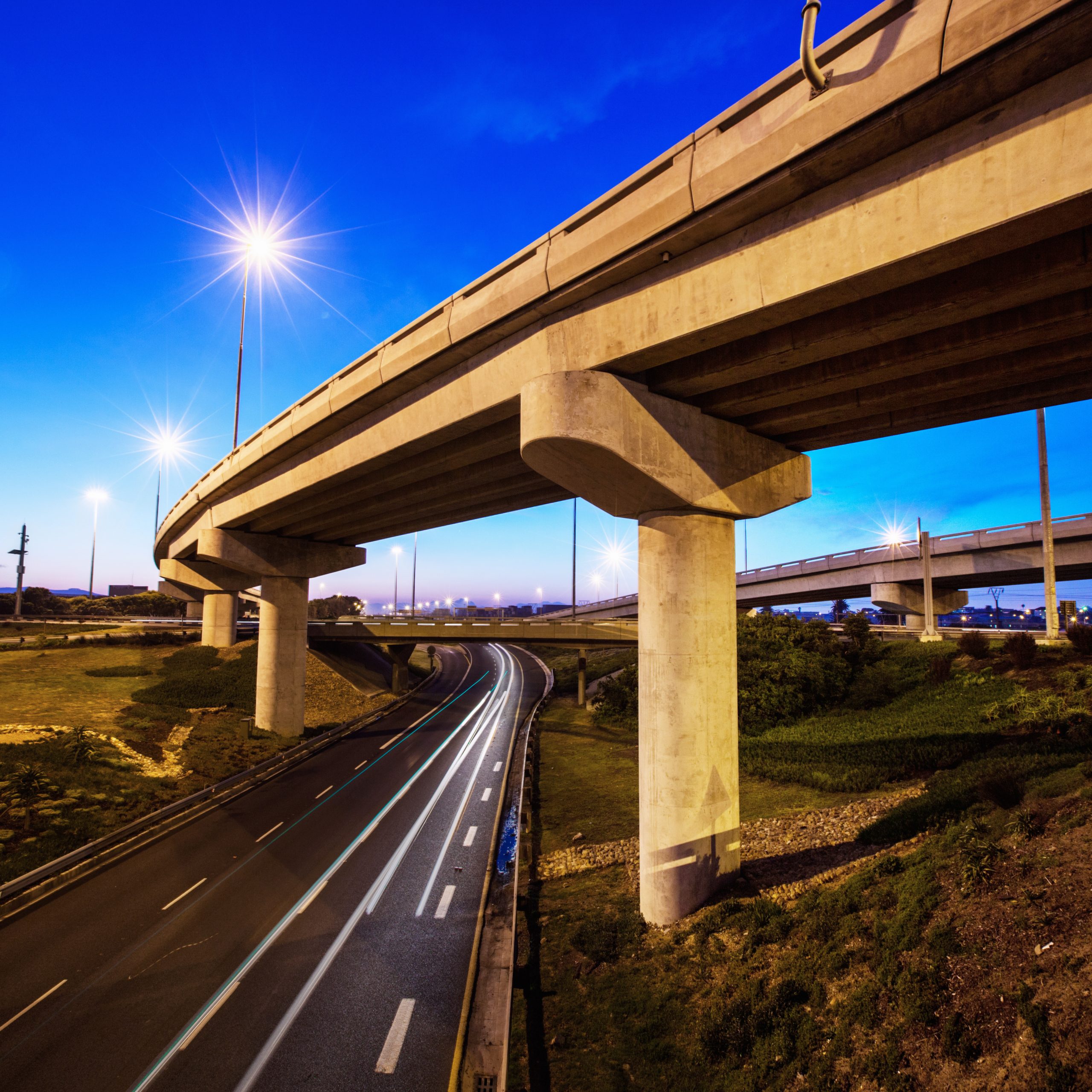 A cropped shot of a concrete overpass on a stretch of road